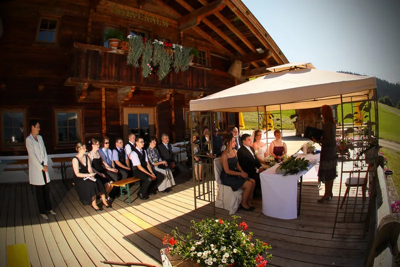 Berghochzeit Kitzbühel – Brautpaar Hand in Hand auf der Alm