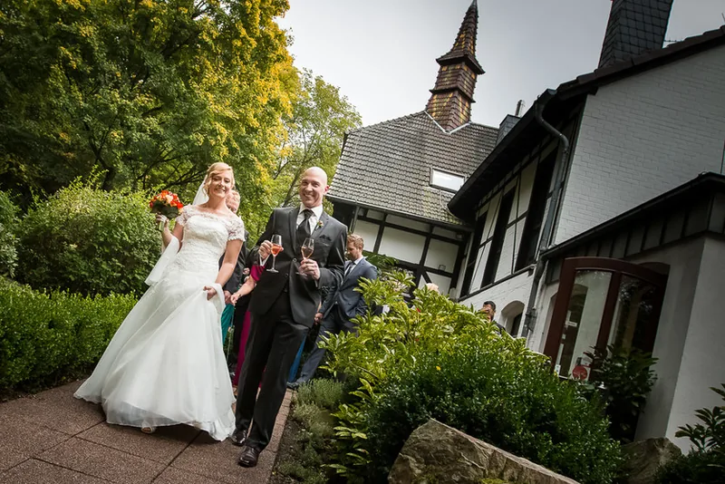 Villa im Tal – Brautpaar Hand in Hand vor der Villa